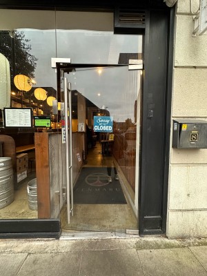 Glass door. Handle on left, push to open.