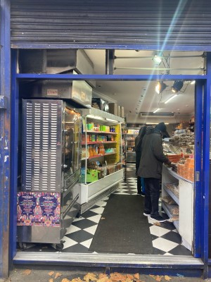 Glass door with blue frame ahead. Slide to open via metal handle on left.