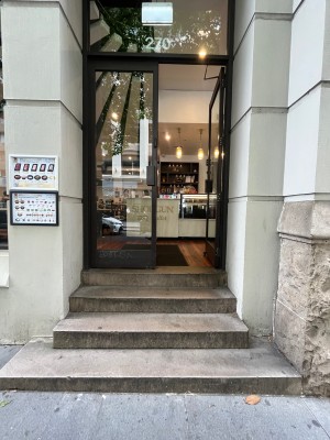 Glass double doors with black frame. Push from black metal handles in middle.