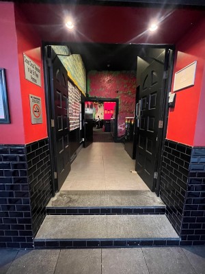 Black wooden double doors. Push from middle. Doors typically open during business hours.
