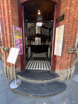 Red wooden doors with glass panels. Push from middle.