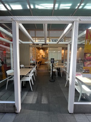 Open archway to outdoor front area. Entrance door on wall ahead to left after seating.