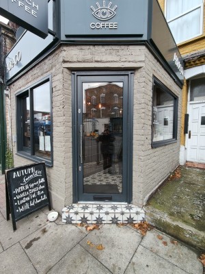 Grey framed door. Push or pull silver metal handle on left to open. Dog assistance bowl on left.