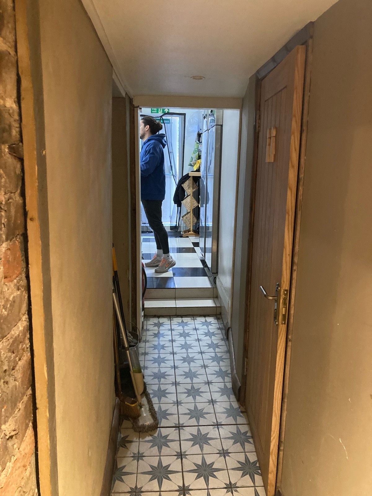 From archway, facing left. Path ahead to bathroom door on right.