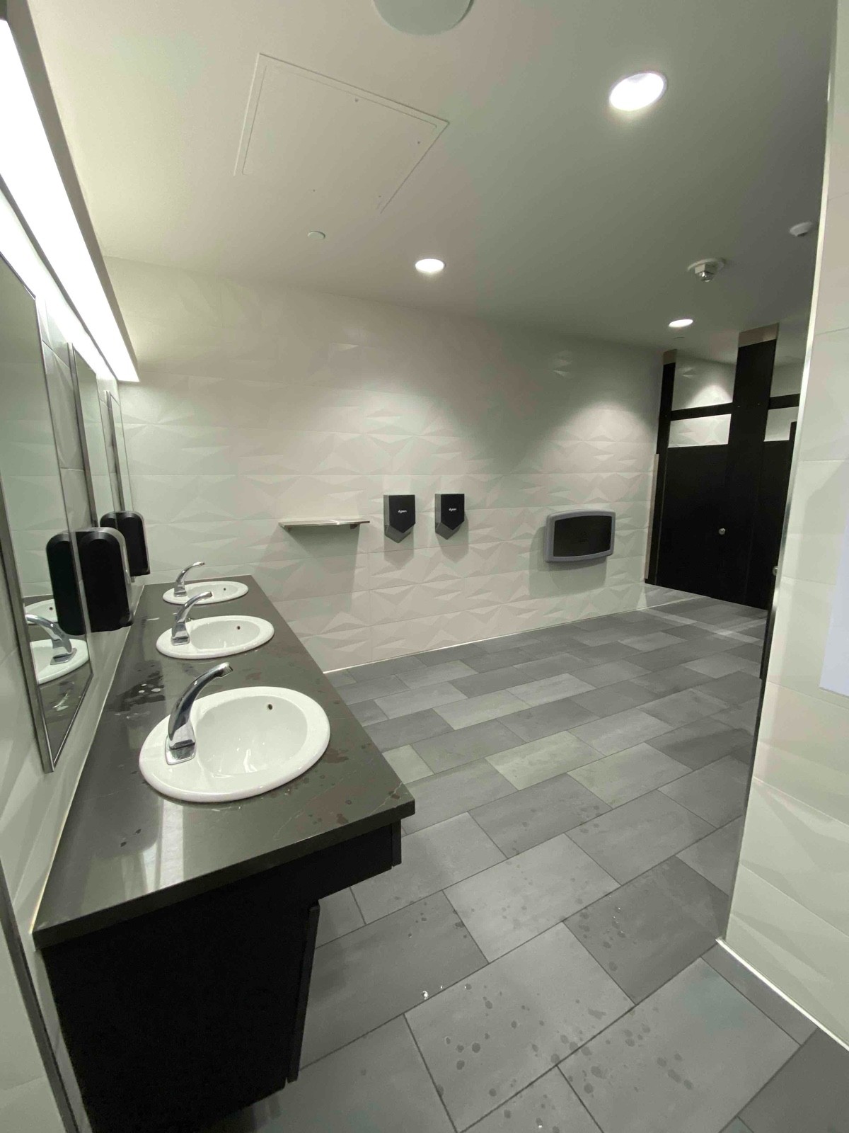 Sinks at medium height, automatic sinks, soap dispensers, and hand dryers.