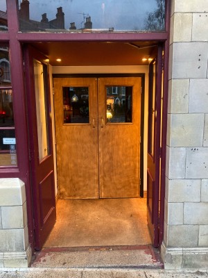 Red doors with glass panels ahead. Push to open from center.