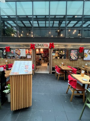 Path to entrance through outdoor front seating. Menu stand obstructing on left. Door directly ahead.