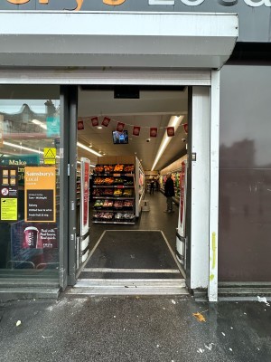 Glass door with grey frame. Slides open to left.