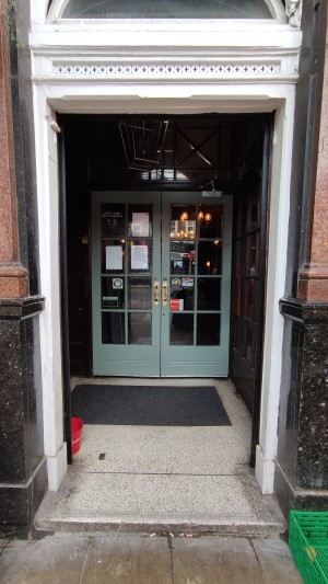 From pavement facing straight. Open archway ahead.