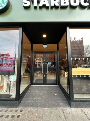 From pavement, facing venue. Opening ahead.