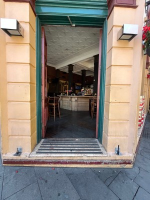 Glass double doors with brown wooden frame. Push from middle.