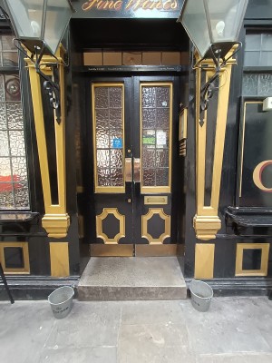 Glass doors with black frame. Push from middle to open.