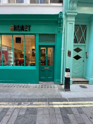 Green wood and glass panelled door ahead. One step up before door. Push brass knob on left to open.