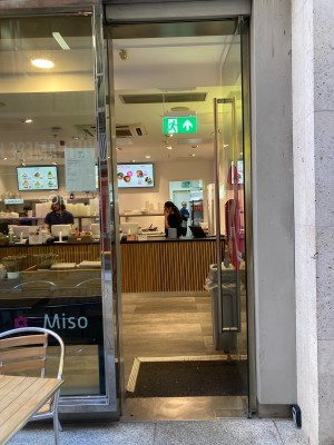 Glass door ahead. Push to open via metal hand rail on left.