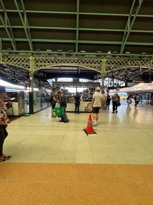 No door leading to kiosk counter. Traffic cone obstructing path to counter.