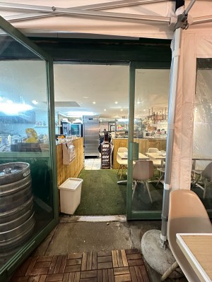 Glass doors with green frame. Pull metal handles in centre to open.