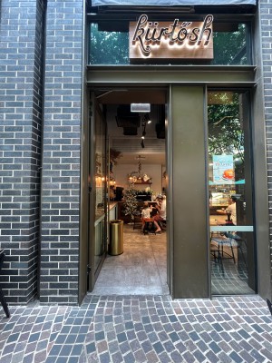 Glass door with brown metal frame. Push from right. Door typically open.
