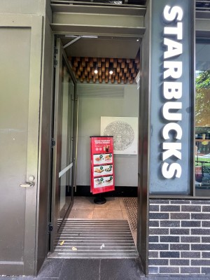 Glass door with grey metal frame. Push from right.