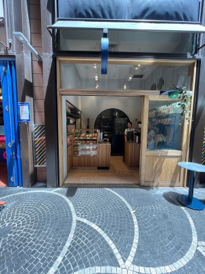 Glass door with beige wooden frame slides open to right. Door typically kept open.
