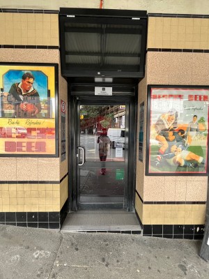 Glass door with black metal frame. Push from left.