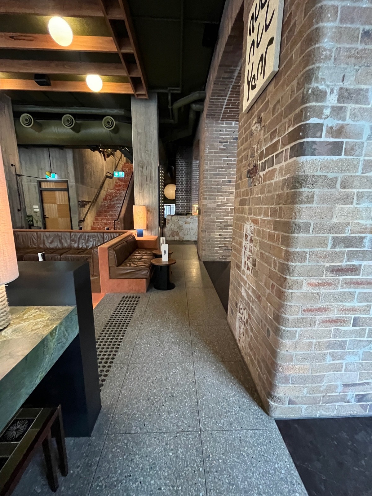From table facing right. Downstairs area on left wall followed by half booths with low tables.
