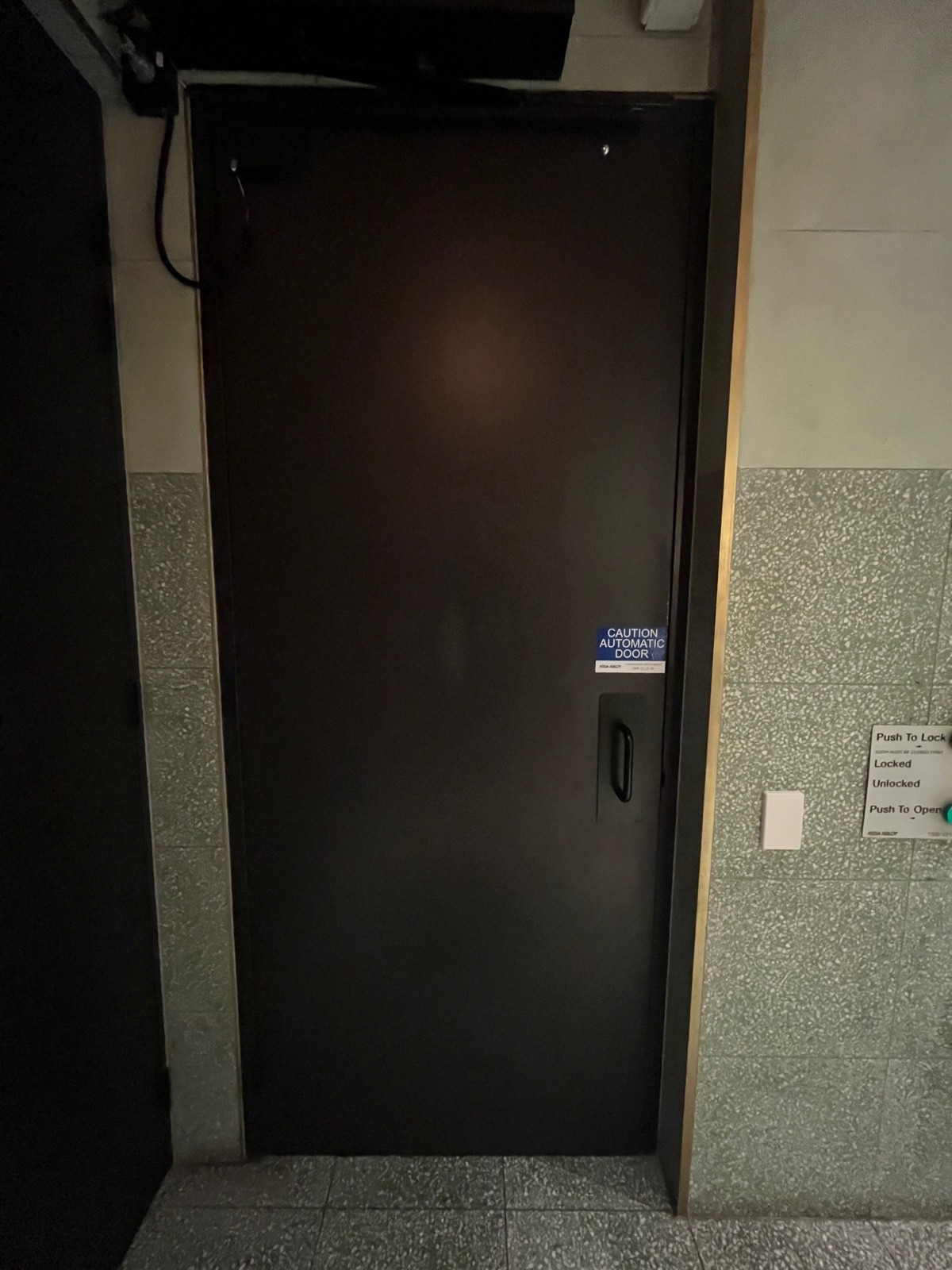 Back of door. Door opens inwards when button is pressed.