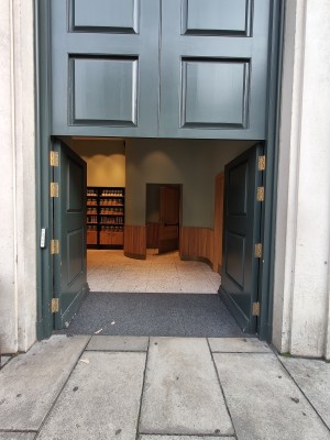 Green doors. Push from centre to open. Doorbell for assistance on left of doors.