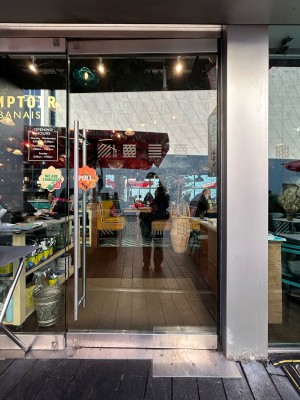 Clear glass door with silver handle on left. Pull to open.