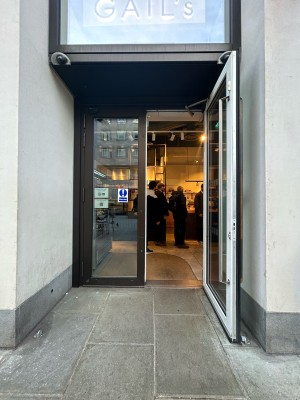 Glass doors with brown frame open outwards. Push power button on right to open.
