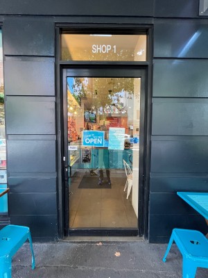 Glass door with black metal frame. Push from left.