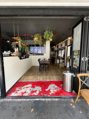Glass door with black metal frame folds open to right. Door typically kept open.