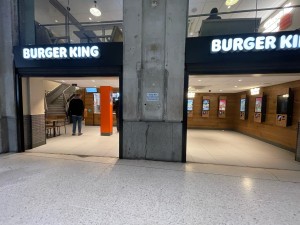 From path facing venue. Two wide open archway entrances divided by concrete wall lead to main area.