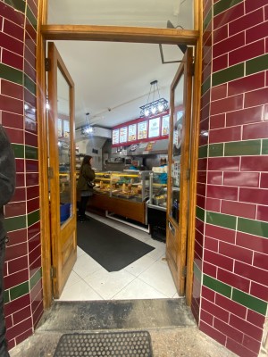 Double glass door, with wooden doorframe. Push at centre to open.