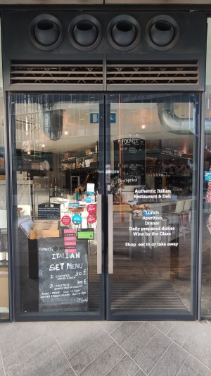 Glass doors with black frames. Pull metal handles in centre to open.
