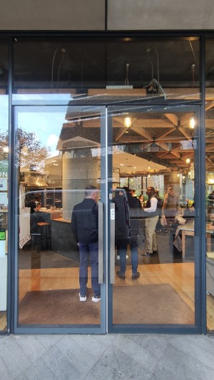 Glass doors with black frames. Pull metal handles in centre to open.