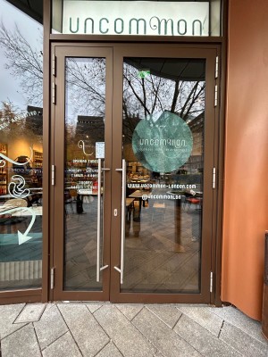 Brown-framed glass doors with metal handles in middle. Pull to open.