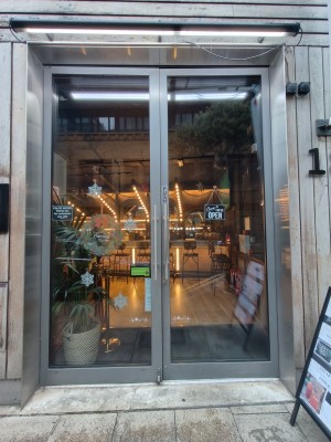 Facing grey framed glass doors. Push silver metal handles in centre to open.
