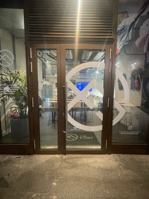 Glass doors with brown frame ahead. Silver metal handle in centre. Pull to open.