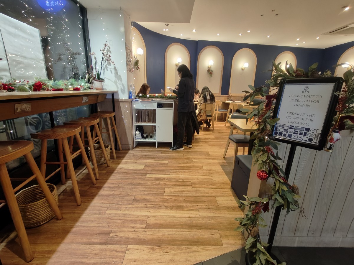 From entrance facing left. High table and stools on left. Staff desk ahead. Seating on right.