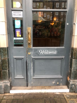 Grey wooden and glass panelled doors. Pull metal handle to left of right hand door. Leaf can also be opened.