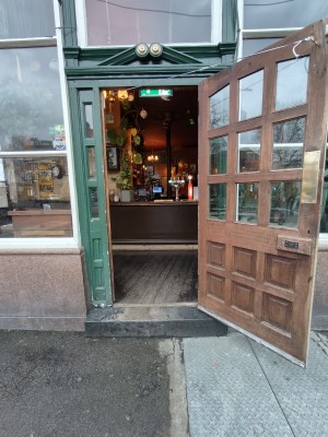 Wooden framed glass door ahead. Pull from left to open.