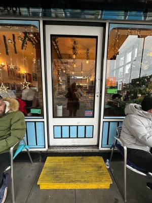 White and blue metal and glass panelled door. Push metal handle on right to open.