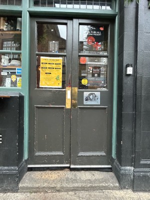 Dark grey doors with glass panels ahead. Push from middle to open.