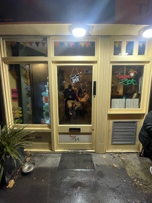 Glass door with yellow wooden frame ahead. Push from right to open.