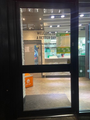 From pavement facing venue. Glass door with black frame ahead. Push from handle on right of door.