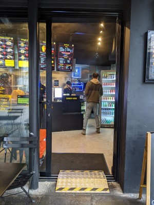 Glass door with black frame and back handle on right. Slides left to open. Ramp on request deployed.
