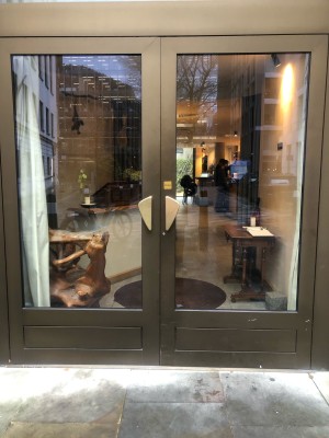 Glass doors with dark green frame. Push metal handle in centre to open.