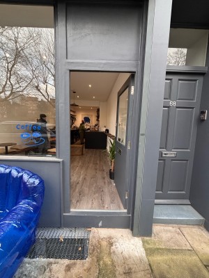 Grey glass paneled door ahead. Push at center left to open.