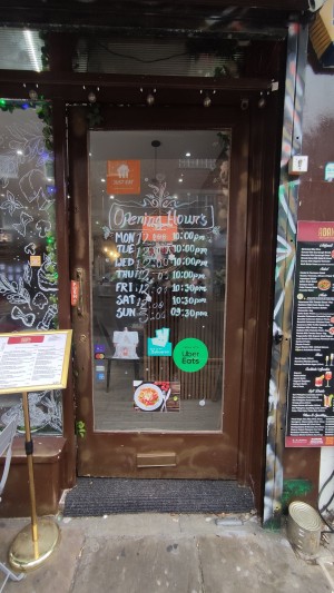 Glass door with brown frames ahead. Push brass handle on left to open.