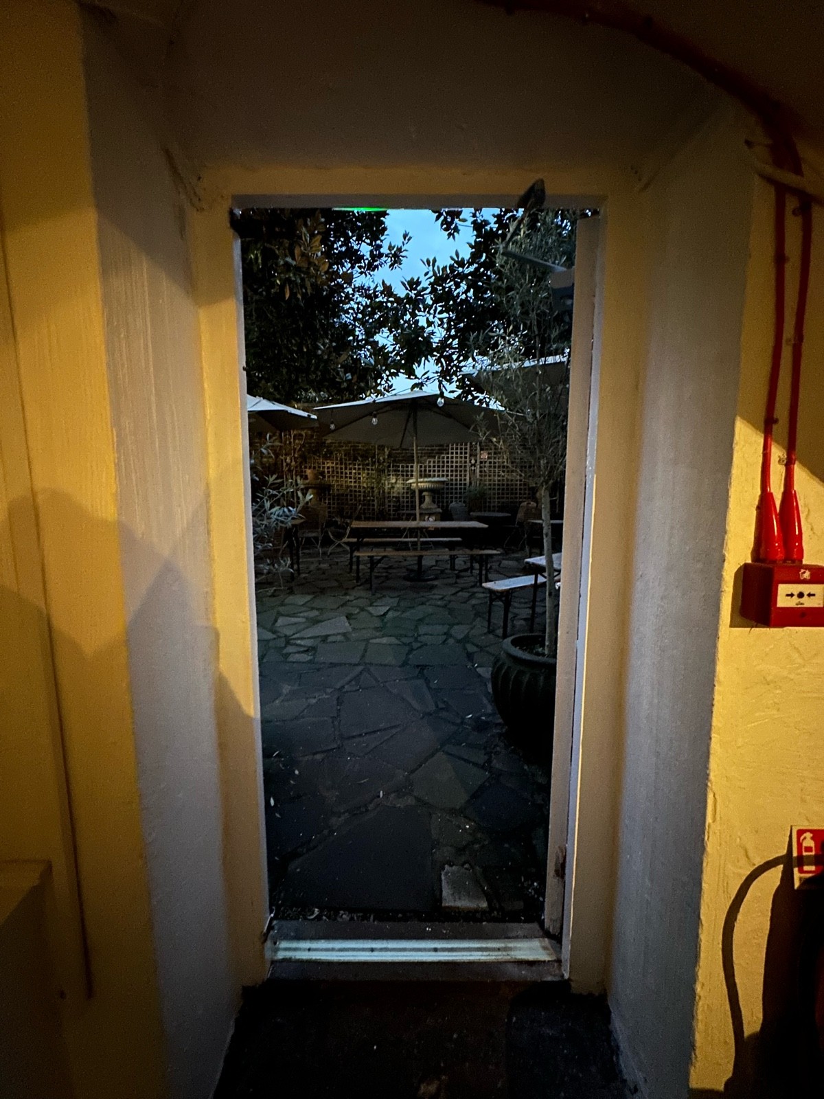 From end of display table facing straight. White wooden preceding door ahead. Push from left to open.